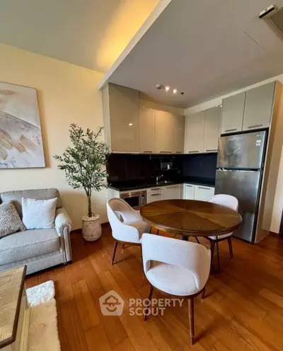 Modern open-plan kitchen and living area with stylish furniture and wooden flooring.