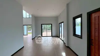 Spacious modern living room with large windows and natural light