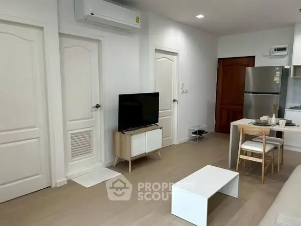 Modern living room with minimalist furniture and sleek kitchen area, perfect for urban living.