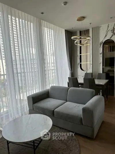 Modern living room with elegant decor and large windows in a high-rise apartment.