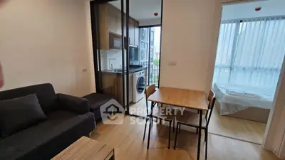 Modern apartment interior with cozy living room, dining area, and compact kitchen.