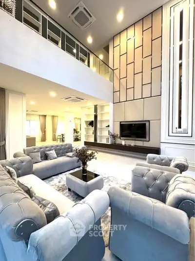 Luxurious double-height living room with elegant sofas and modern decor