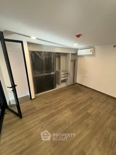 Spacious bedroom with built-in closet and modern air conditioning unit.