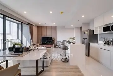 Spacious modern living room with open kitchen and balcony view