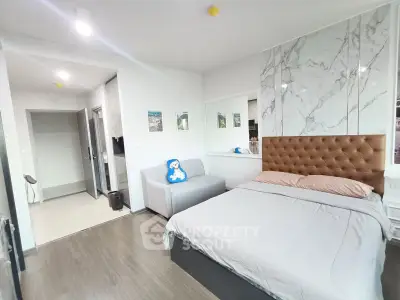 Modern bedroom with stylish decor and cozy seating area in a contemporary apartment.