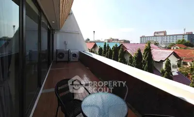 Spacious balcony with city view and outdoor seating area.