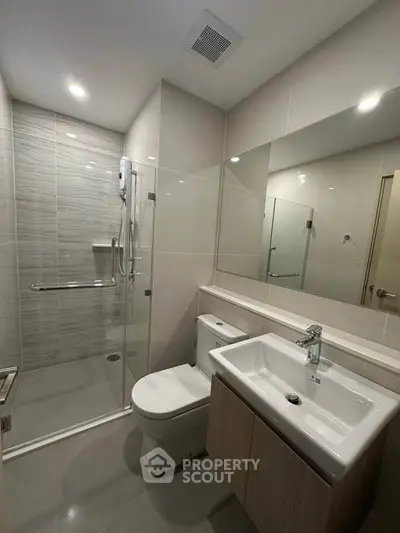 Modern bathroom with sleek fixtures and glass shower enclosure