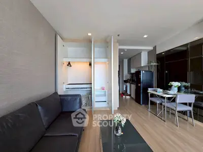 Modern living room with sleek furniture and open kitchen layout in a stylish apartment.