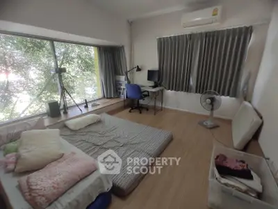 Cozy bedroom with large window, air conditioning, and workspace setup