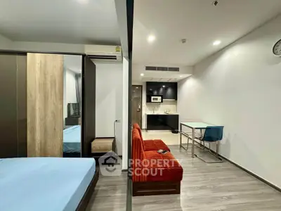 Modern studio apartment with open layout, featuring a cozy living area and sleek kitchen.