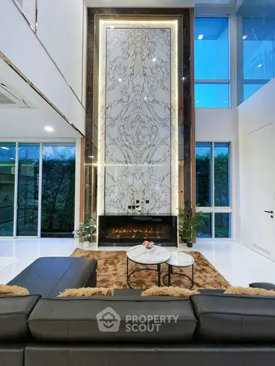 Luxurious modern living room with high ceiling and elegant marble fireplace