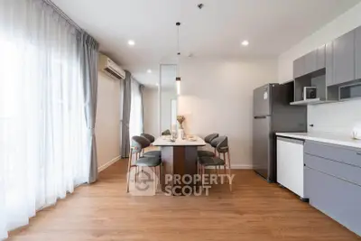 Modern dining area with sleek kitchen and elegant wooden flooring