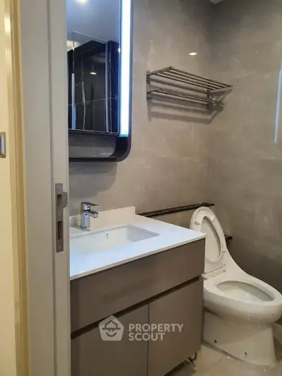 Modern bathroom with sleek fixtures and elegant design, featuring a stylish vanity and contemporary toilet.
