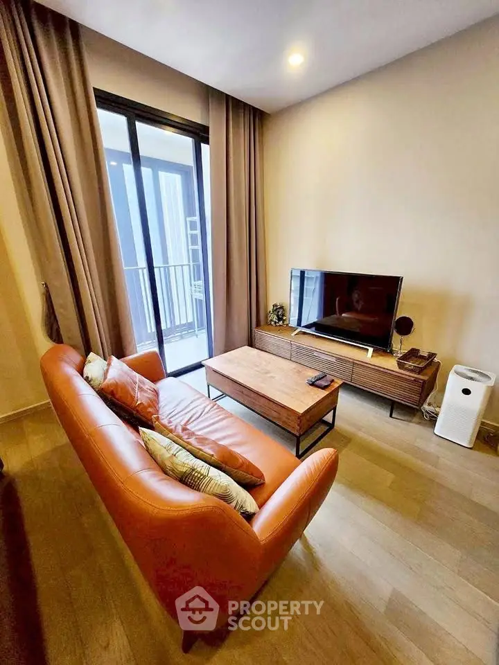 Modern living room with stylish furniture and balcony access in a cozy apartment.