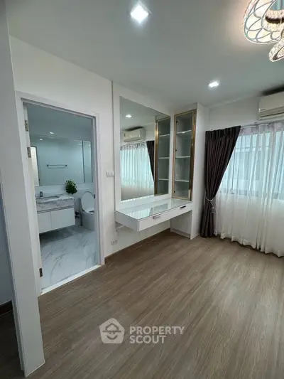 Modern bedroom with ensuite bathroom and elegant wooden flooring