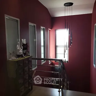 Stylish stairway with modern lighting and red accent walls in a contemporary home.