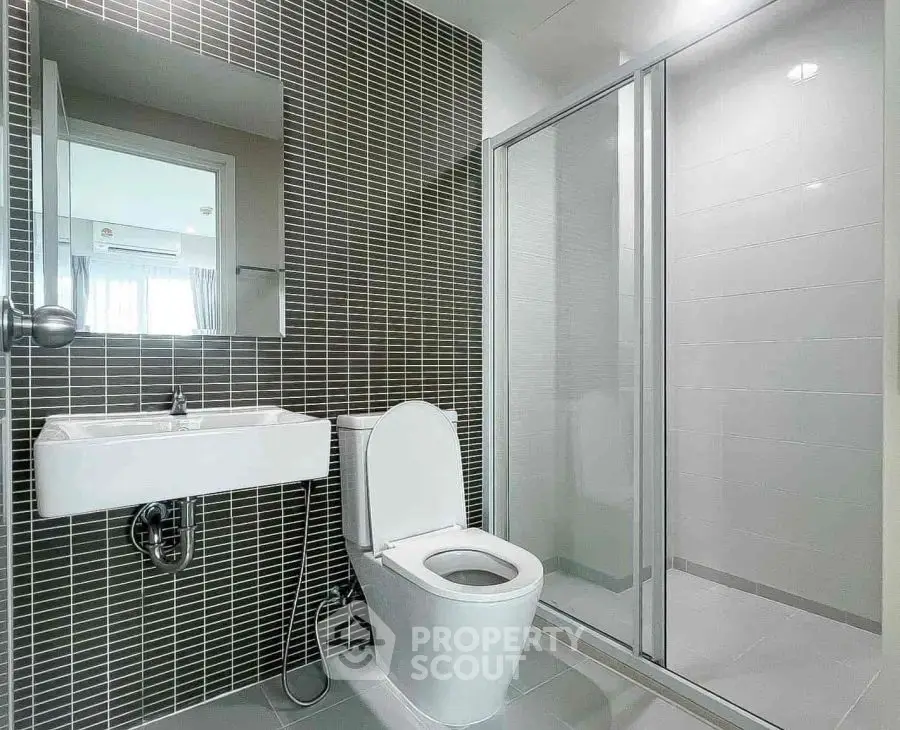 Modern bathroom with sleek design and glass shower enclosure.