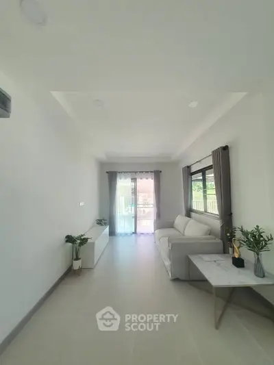 Spacious living room with modern decor and large window for natural light