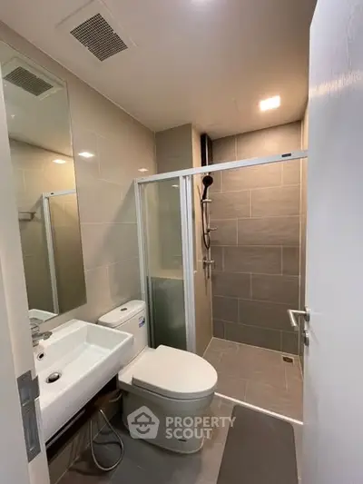 Modern bathroom with sleek shower and contemporary fixtures in a stylish apartment.