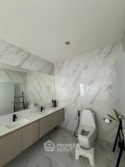 Modern bathroom with dual sinks and elegant marble tiles