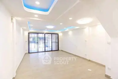 Spacious modern living room with recessed lighting and large windows.
