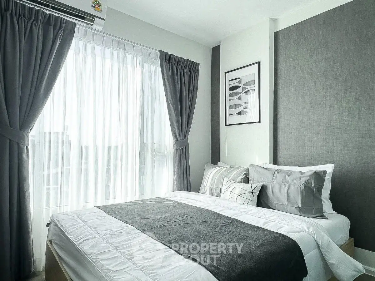 Modern bedroom with elegant gray curtains and stylish bedding in a bright apartment.