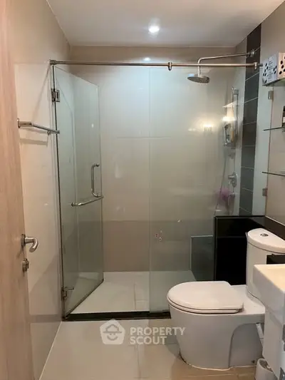 Modern bathroom with glass shower enclosure and sleek fixtures.