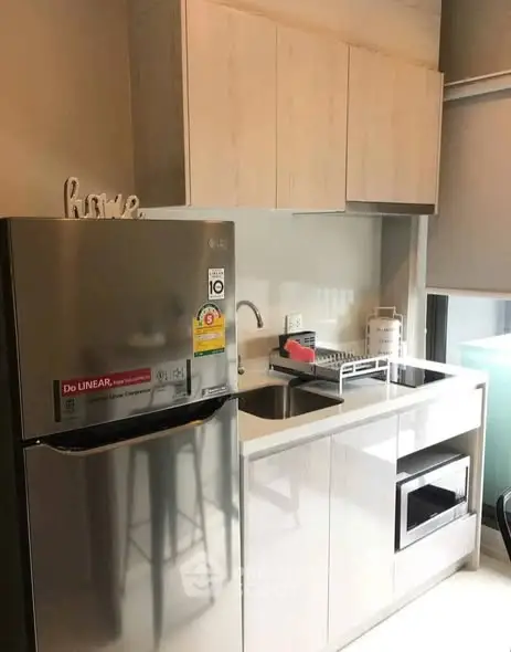 Modern compact kitchen with sleek appliances and stylish cabinetry in a cozy apartment.