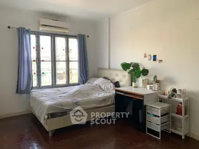 Cozy bedroom with natural light, featuring a stylish bed and modern decor, perfect for relaxation.