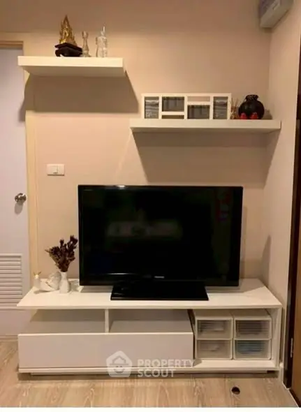 Modern living room with sleek TV stand and wall shelves, perfect for stylish home entertainment setup.