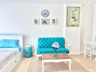Charming living room with turquoise sofa and stylish decor in a cozy apartment.