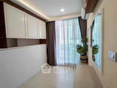 Modern bedroom with large window and stylish decor in a contemporary apartment.