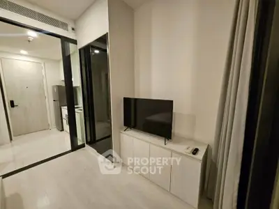 Modern living room with sleek TV setup and minimalist decor in a stylish apartment.