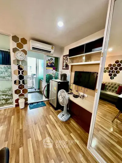 Modern living room with wooden flooring, wall-mounted TV, and balcony access in stylish apartment.