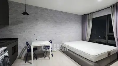 Modern studio apartment with stylish brick wall, cozy bed, compact dining area, and city view.