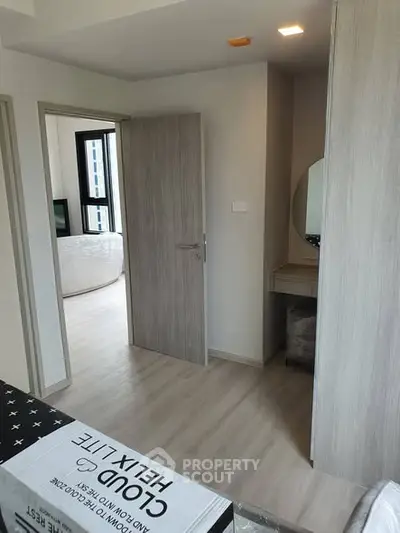 Modern bedroom with sleek wooden flooring and stylish furniture in a contemporary apartment.