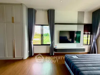 Spacious modern bedroom with large windows and stylish decor, perfect for comfort and relaxation.