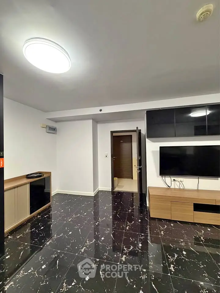 Modern living room with sleek black marble flooring and wall-mounted TV
