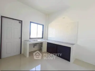 Spacious kitchen with sleek countertops and ample natural light, perfect for culinary enthusiasts.