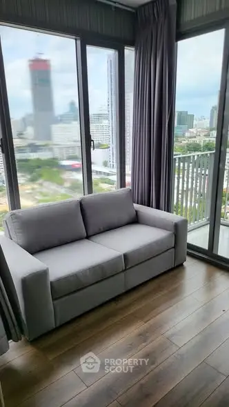 Modern living room with panoramic city view and cozy gray sofa.