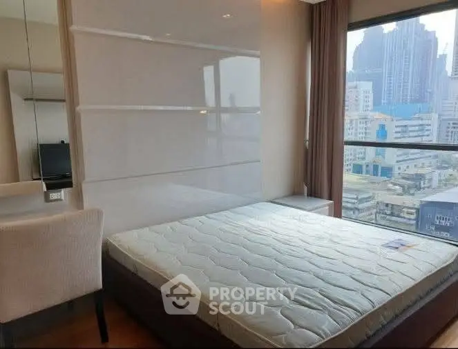 Modern bedroom with city view, featuring a comfortable bed and stylish decor.