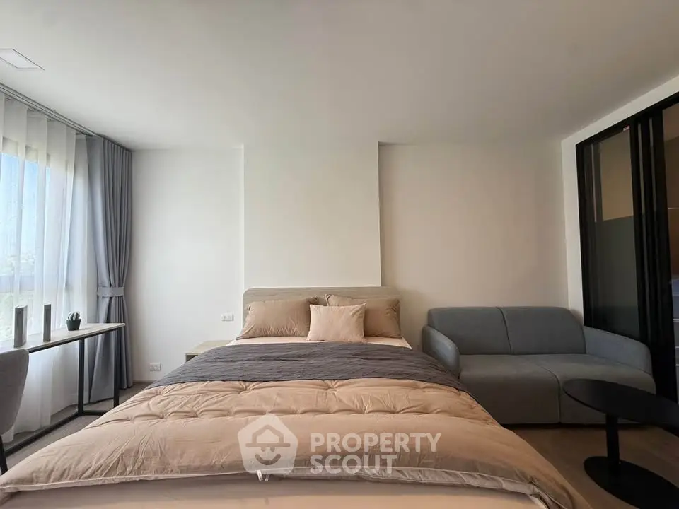Modern bedroom with cozy bed and stylish sofa in a bright apartment