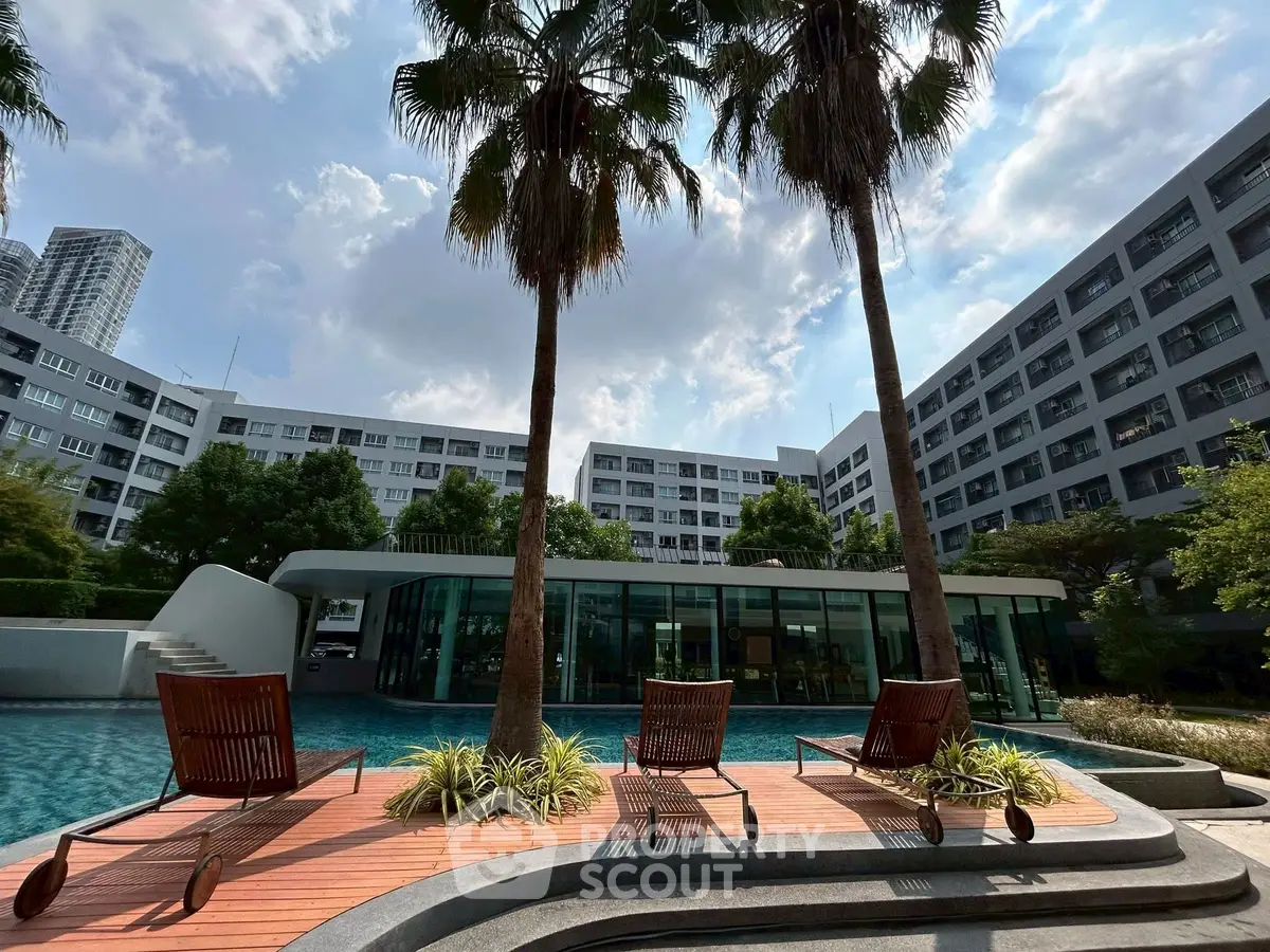 Luxurious poolside view with modern architecture and palm trees, perfect for relaxation.