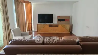Spacious living room with modern furniture and large TV, perfect for relaxation and entertainment.