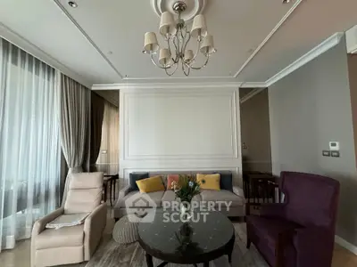 Elegant living room with plush seating, chandelier, and large windows for natural light.