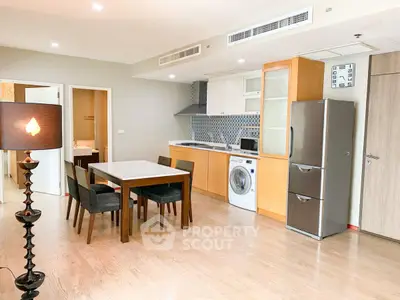 Modern open-layout kitchen with dining area, featuring sleek appliances and stylish decor.