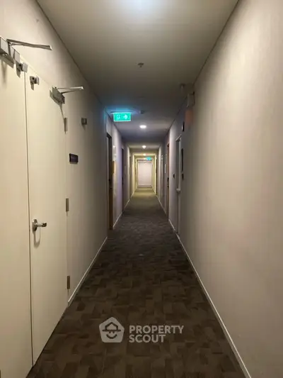 Spacious apartment corridor with modern lighting and carpeted flooring.