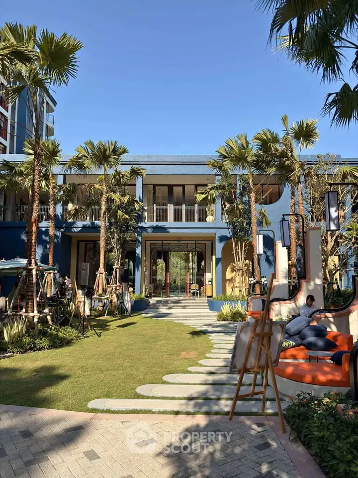 Stunning modern building exterior with lush garden and palm trees, perfect for luxury living.