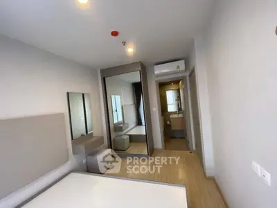 Modern bedroom with ensuite bathroom and mirrored wardrobe in stylish apartment.