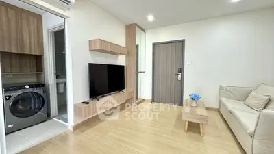 Modern living room with TV, sofa, and washing machine in stylish apartment.